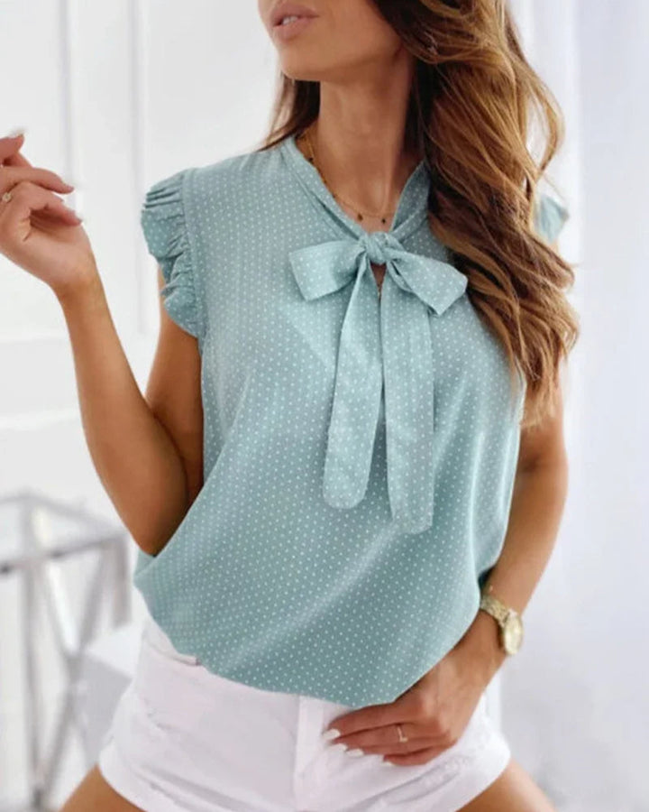 Sleeveless blouse with ruffles and bow details