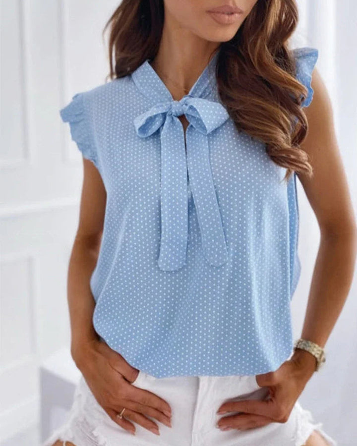 Sleeveless blouse with ruffles and bow details