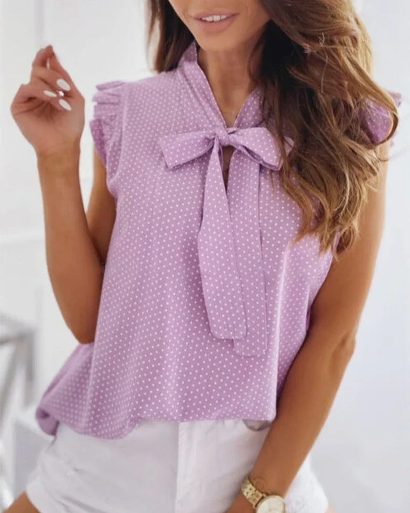 Sleeveless blouse with ruffles and bow details