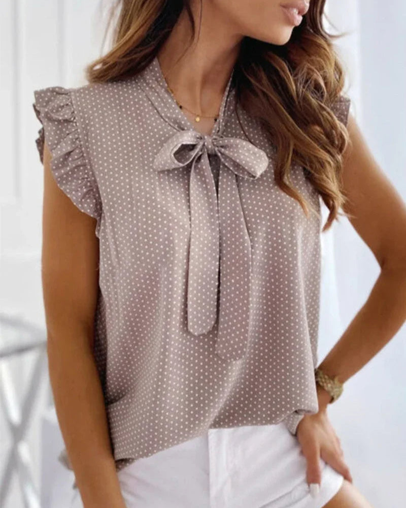 Sleeveless blouse with ruffles and bow details